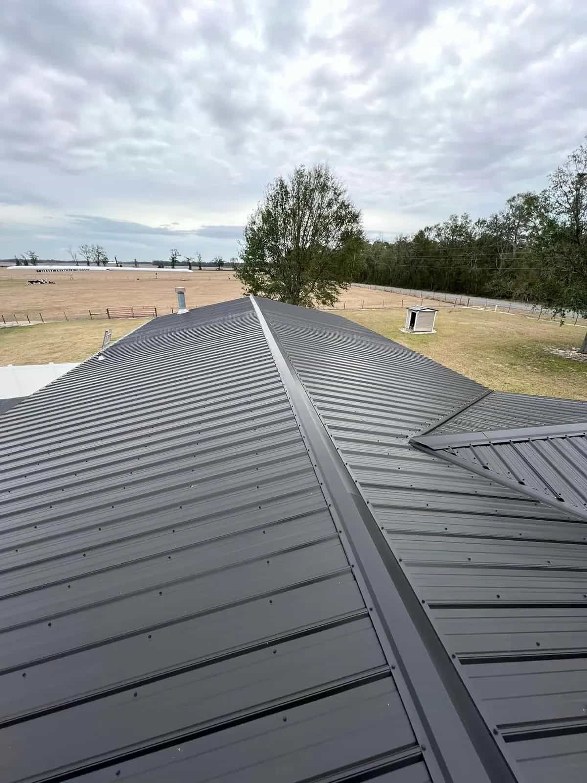 Completed gray metal roof with finished ridge and valley details
