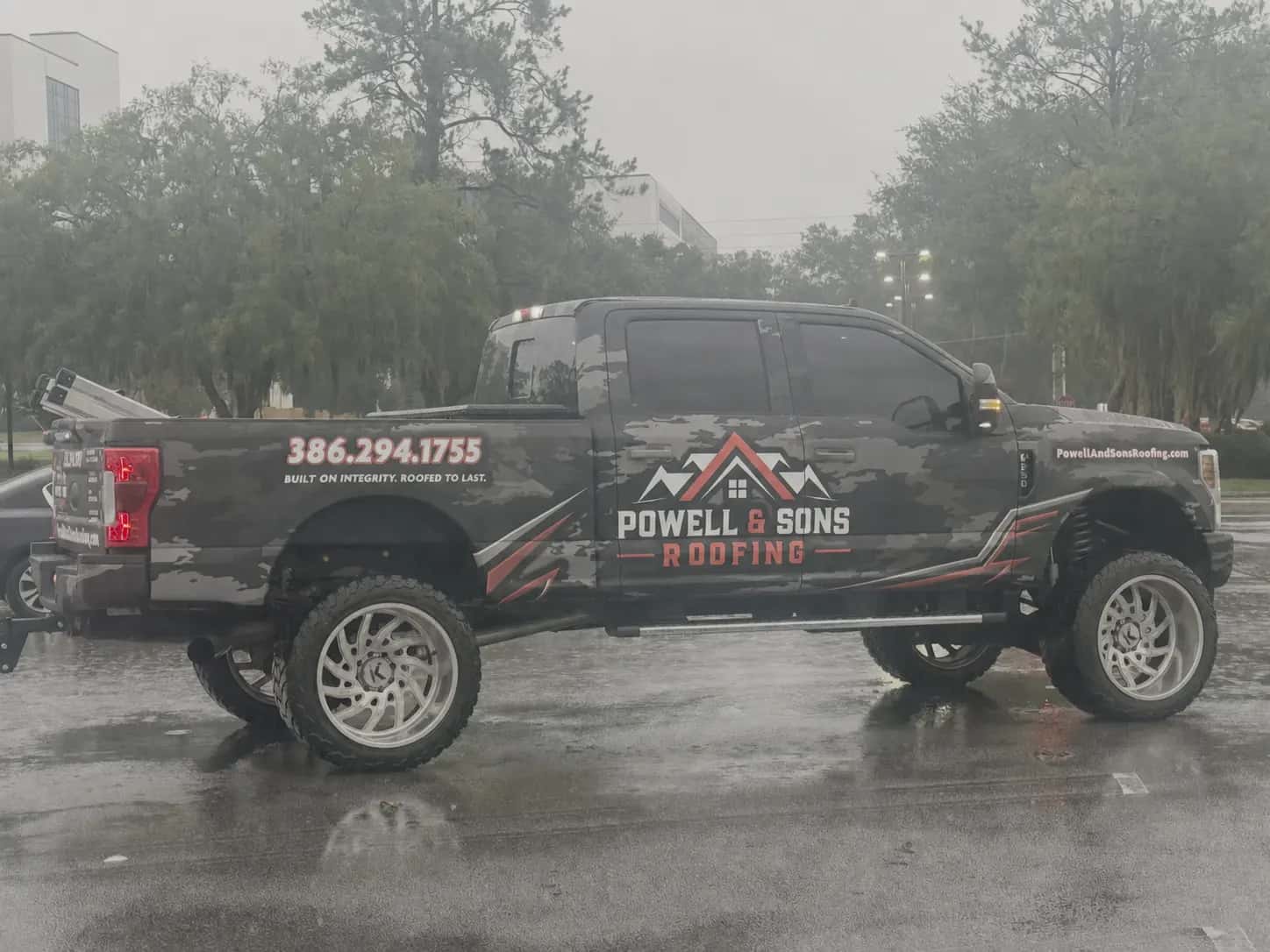 Powell and Sons Roofing truck parked after rainfall