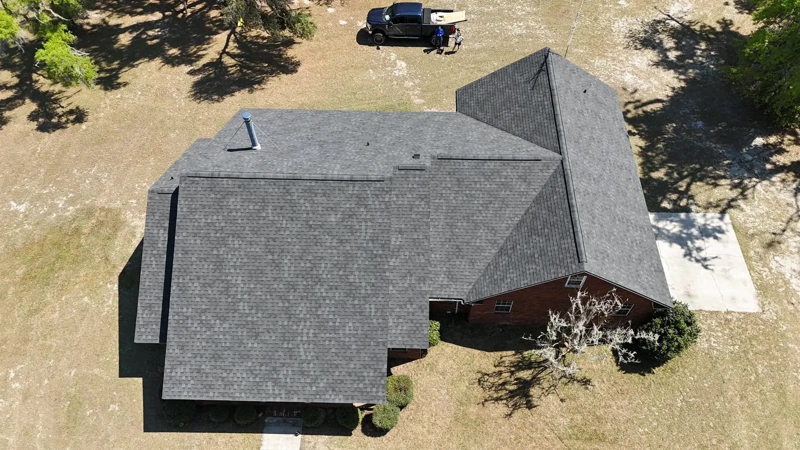 Aerial view of a completed charcoal shingle roof on a single-story home