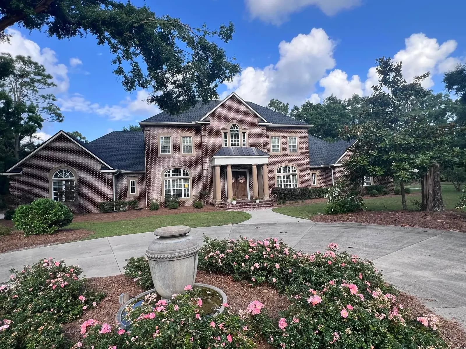 Large brick home with a completed gray architectural shingle roof