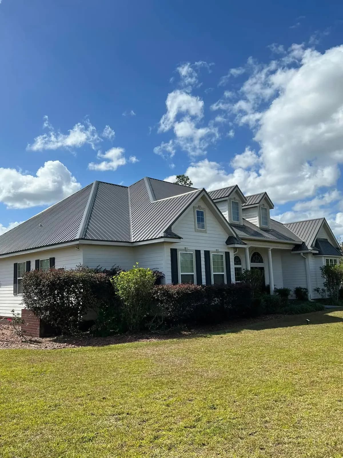 Light-colored home with a completed gray standing-seam metal roof