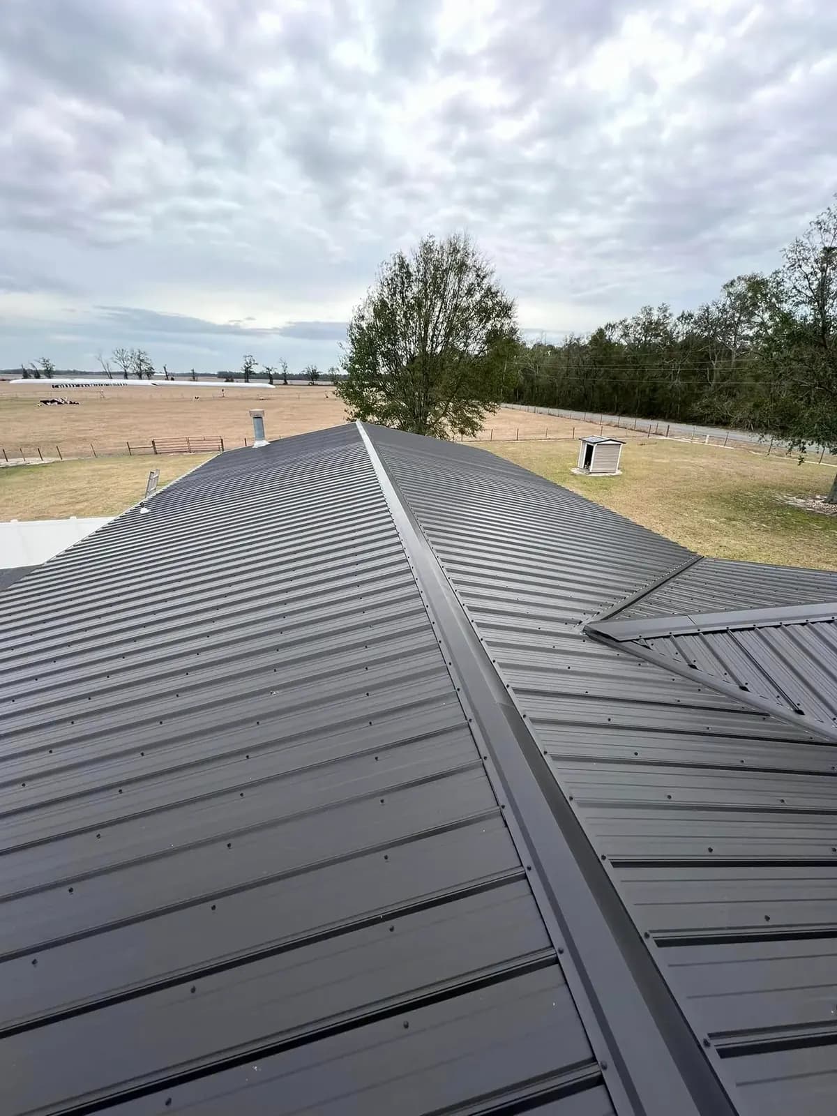 Close view along the ridge of a completed gray metal roof